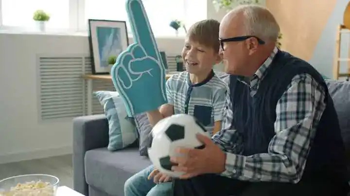 Großvater und Enkel freuen sich gemeinsam über Fußball.